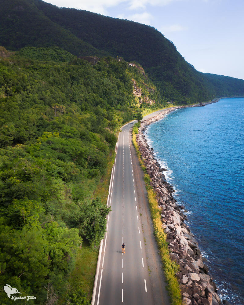 Photo prise au drone. Une route sépare la forêt guadeloupéenne à la mer des Caraïbes.
